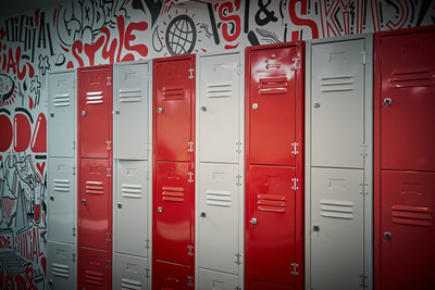 Bespoke grey, white, red and pink lockers on a graffiti wall