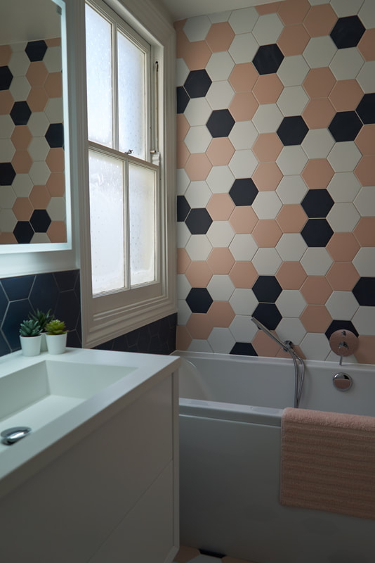 Family bathroom with a mix of pink, white and navy hexagonal tiles