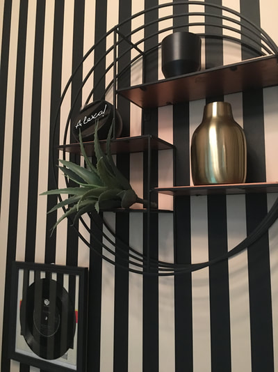 Circular shelf unit from Graham and Green with Alexa Spot on black and white stripy wallpaper