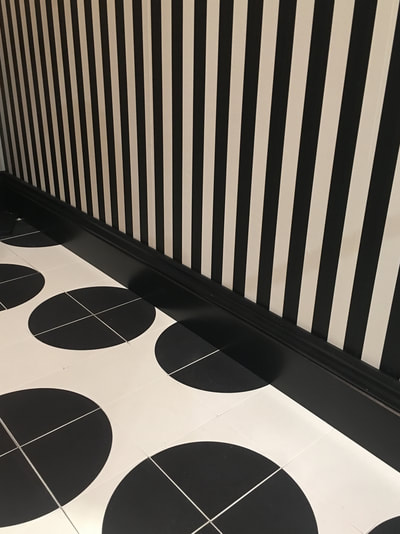 Lavatory with, black and white polka dot floor tiles from Designworks, Clerkenwell, black and white, vertical striped wallpaper and black skirting board