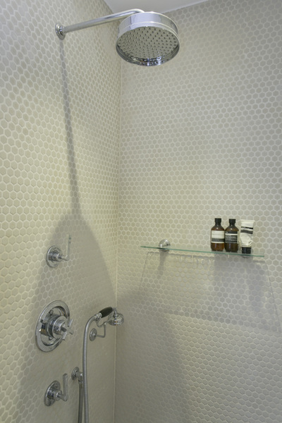 Wet-room with white, round, Penny mosaic, Aesop bottles, glass shelf and Victorian style brassware