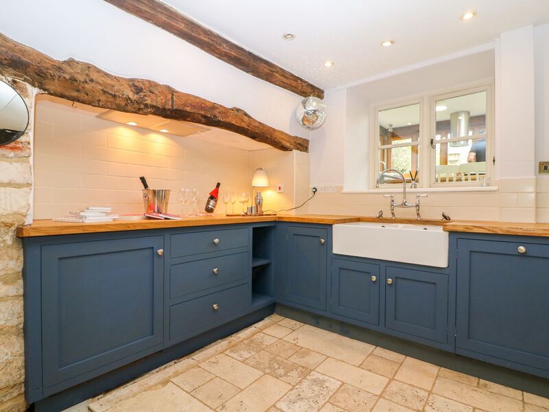 Blue shaker style kitchen with double ceramic sink and limestone flagstones