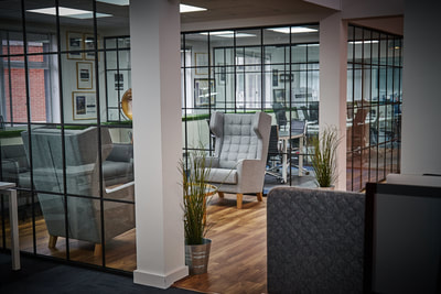 Reception area of Open plan, recruitment office with critical-style partition walls, walnut Amtico floor, grey, padded desk partitioning and grey wingback chairs