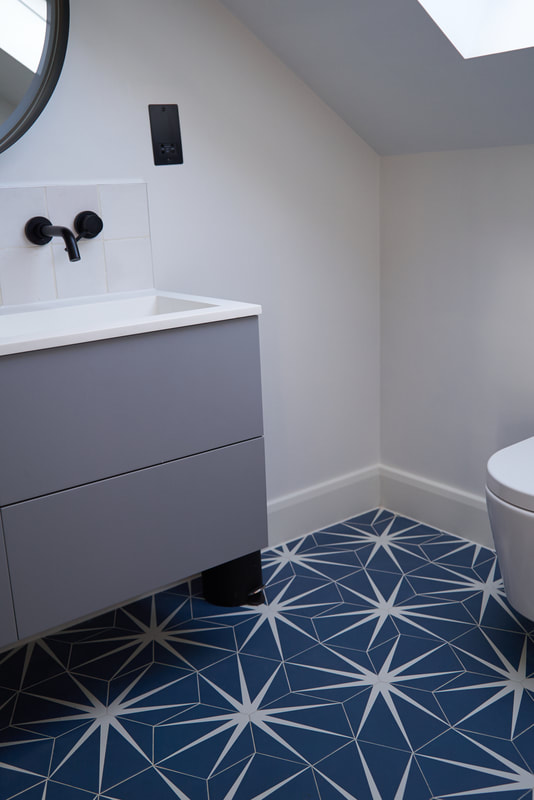 Bathroom with blue Lilypad tiles from Ca Pietra with a matte, grey, wall-hung sink, vanity, unit and minimal black taps and loo from Lusso Stone
